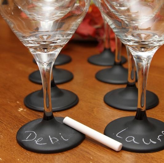 Une décoration de table de Noël ingénieuse avec les prénoms des convives écrits sur le pied des verres.