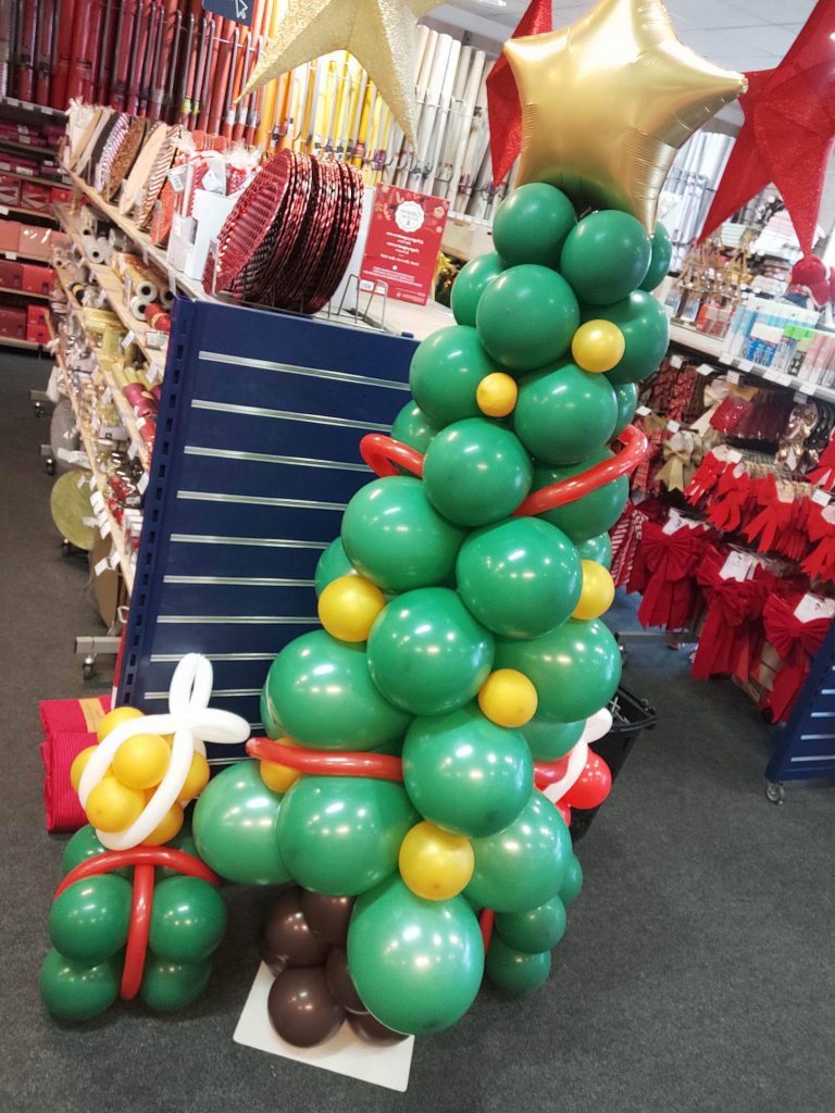 Un sapin tout en ballons avec ses guirlandes et ses boules de Noël. Un sapin vert avec des ballons de fête qui ne perd pas ses épines !