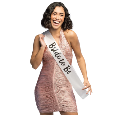Jeune femme souriante portant une écharpe de fête en satin avec l'inscription Bride to Be pour un enterrement de vie de jeune fille | jourdefete.com