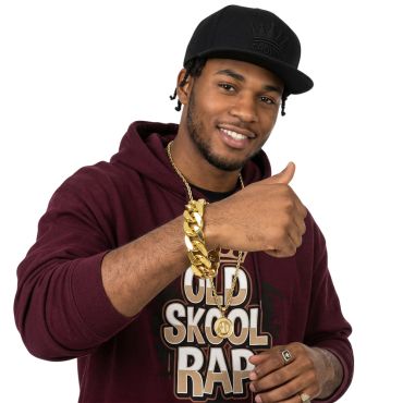 Homme souriant avec une tenue de rappeur et un gros bracelet chaîne en or bling-bling | jourdefete.com