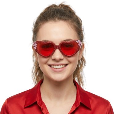 Femme souriante portant des lunettes de soleil en forme de cœur rouge avec des paillettes | jourdefete.com