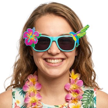 Femme joyeuse portant des lunettes de soleil turquoise fantaisie avec décoration hibiscus et colibri pour une fête hawaïenne | jourdefete.com