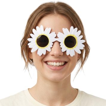 Femme souriante portant de grandes lunettes de soleil en forme de fleurs de marguerite blanches | jourdefete.com