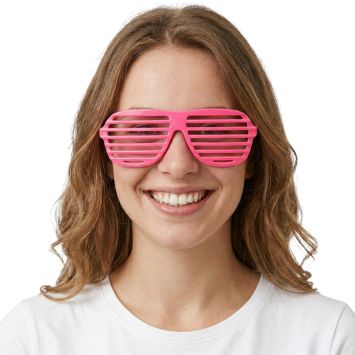 Femme souriante portant des lunettes obturateur rose fluo pour une soirée à thème | jourdefete.com