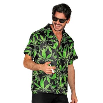 Homme souriant portant une chemise noire à motifs feuilles de cannabis vertes et lunettes de soleil.